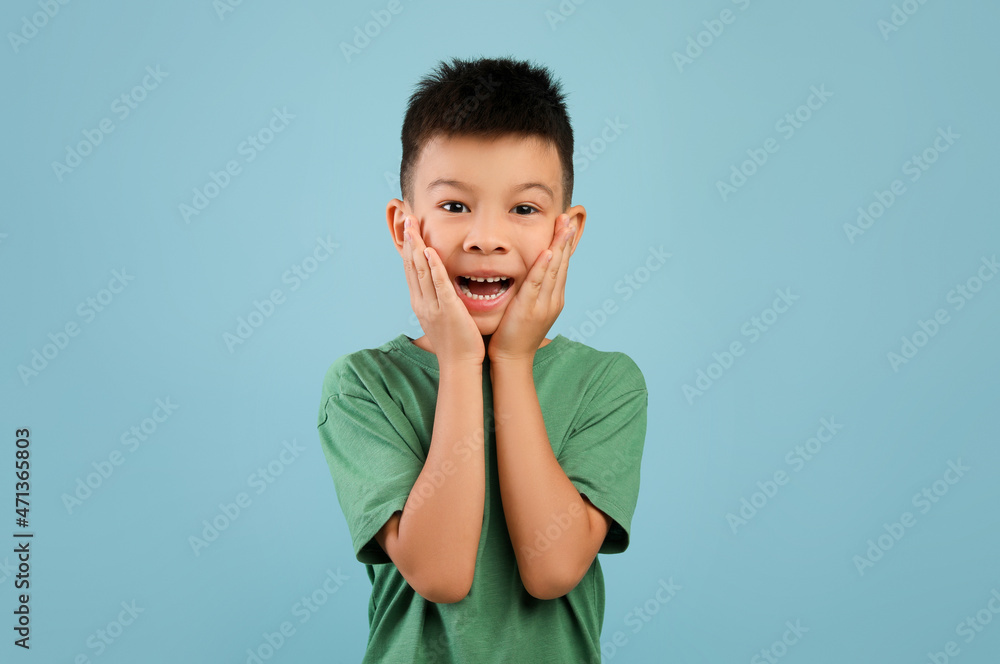 Portrait of surprised little asian boy touching face with excitement Portrait of surprised little asian boy touching face with excitement