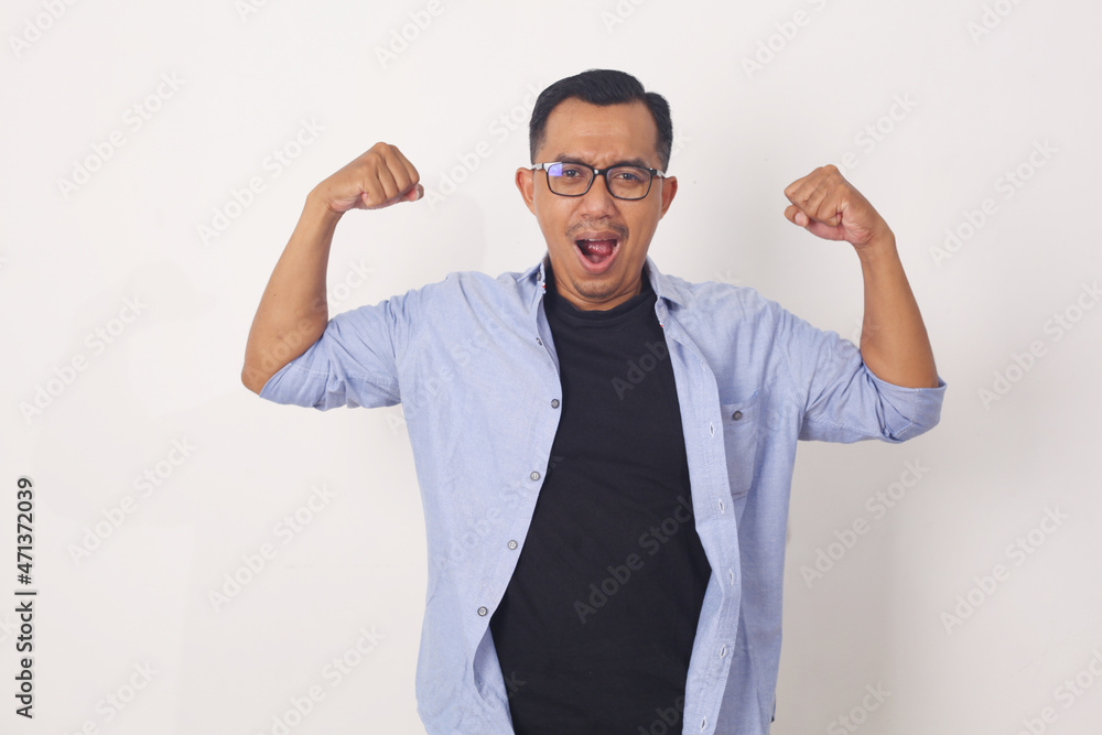 Funny Asian man shows double biceps pose pretending to be a strong person physically and mentally, showing self confidence Funny Asian man shows double biceps pose pretending to be a strong person physically and mentally, showing self confidence