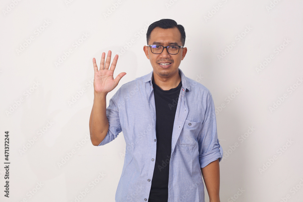 Young asian man smiling cheerful showing number five with fingers. Young asian man smiling cheerful showing number five with fingers.