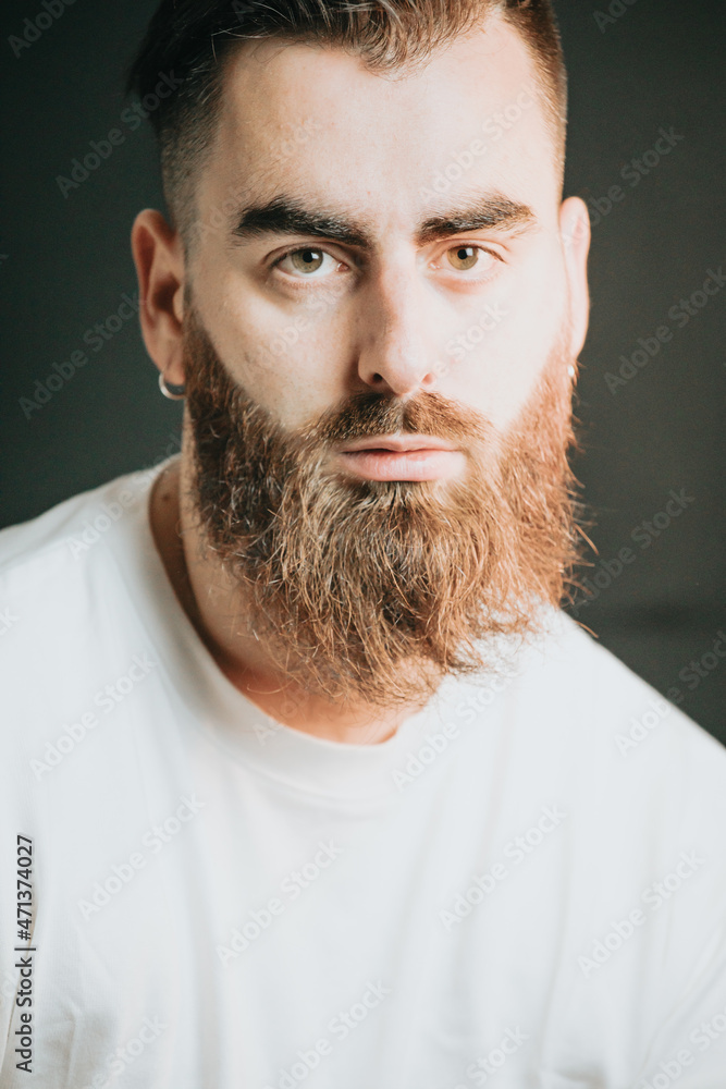 Cinematic shot of a young hipster bearded man with modern hairstyle with  cinematic lighting. Attractive man looking serious straight to camera,  mental health concept. Depression and anxiety portrait Stock Photo | Adobe