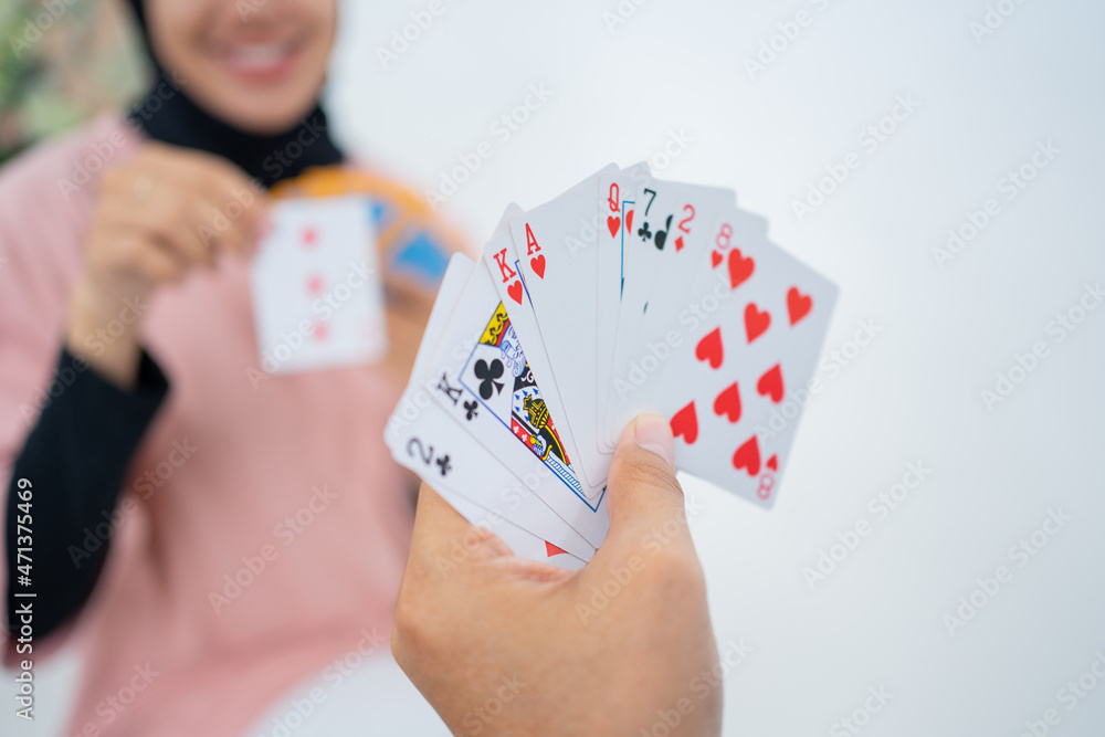 Close up of hands holding cards while playing cards Close up of hands holding cards while playing cards