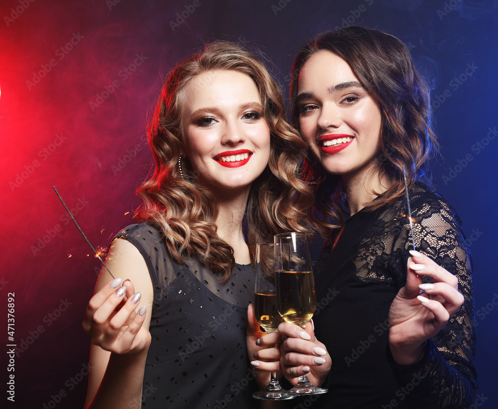 Party time. Two beautiful young women with wine glasses and spar