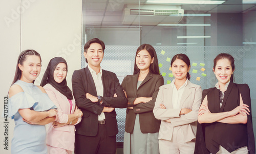 Group of young people smiling and arms crossed in office workplace, Successful business team standing and looking at camera with crossed arms in office