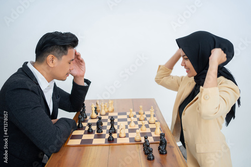 Veiled woman wins against man in suit while playing chess