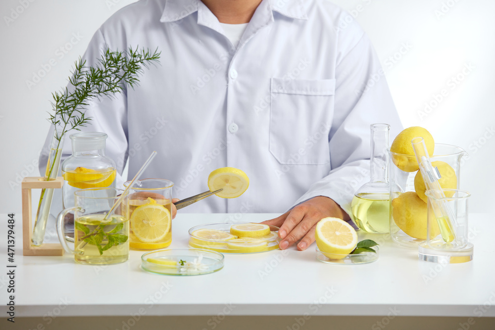White Background with a doctor for Biological experiment presentation lemon extract and yellow water in biological test tubes. Production of cosmetics based on lemon 