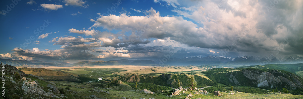Panoramic view of mountain valley, thundercloud, evening light