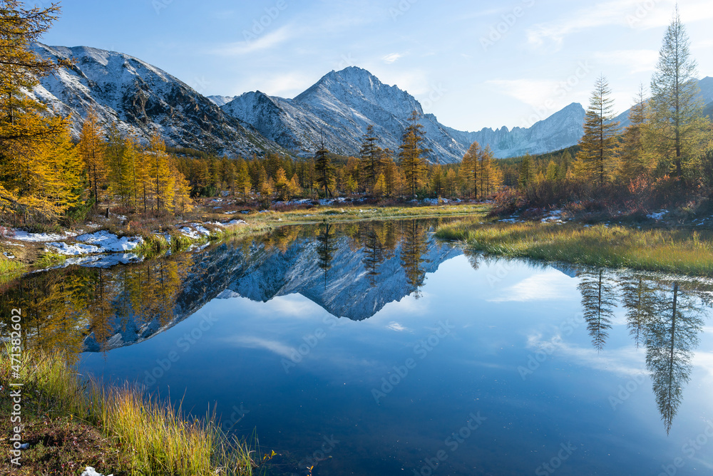 Russia. Magadan Region. A beautiful forest lake against the backdrop of the Big Anngachak mountain range. Autumn in the vicinity of Lake Jack London.