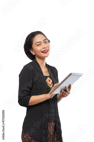 happy asian woman with kebaya using tablet phone