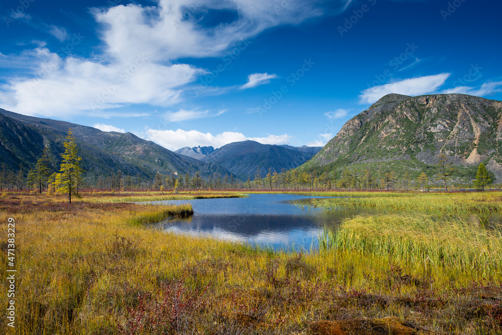 Russia. Magadan Region. A beautiful forest lake against the backdrop of the Big Anngachak mountain range. Autumn in the vicinity of Lake Jack London.   
