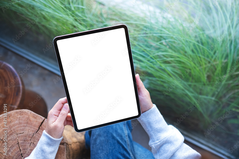 Top view mockup image of a woman holding digital tablet with blank white desktop screen