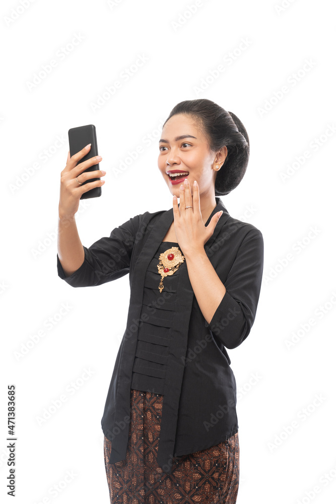 woman with kebaya clothes happy looking at phone woman with kebaya clothes happy looking at phone