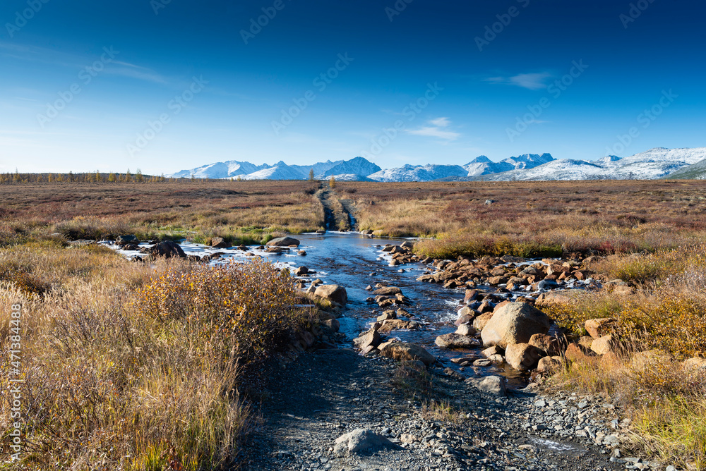 Russia. Magadan Region. A beautiful forest lake against the backdrop of the Big Anngachak mountain range. Autumn in the vicinity of Lake Jack London.