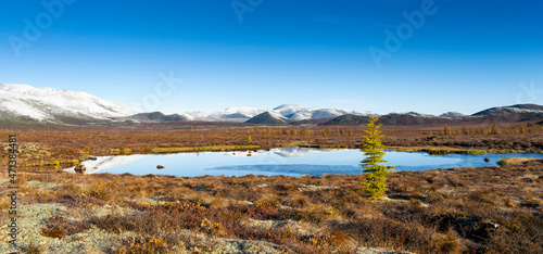 Fototapeta Naklejka Na Ścianę i Meble -  Russia. Magadan Region. A beautiful forest lake against the backdrop of the Big Anngachak mountain range. Autumn in the vicinity of Lake Jack London.