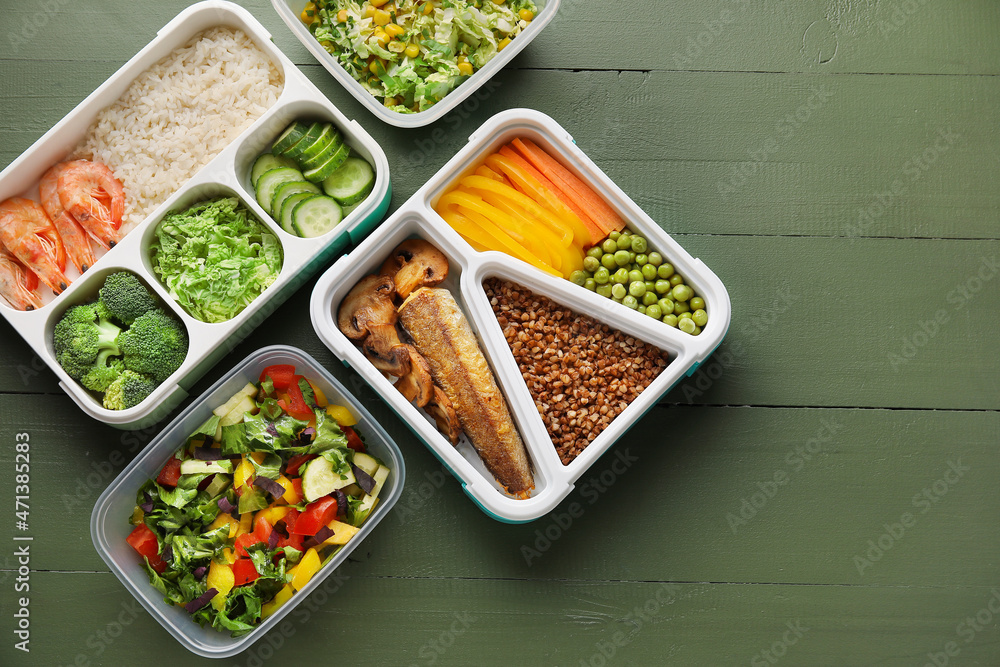 Lunchboxes with tasty healthy food on color wooden background Lunchboxes with tasty healthy food on color wooden background
