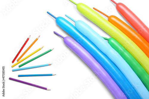 Colorful balloons and pencils on white background