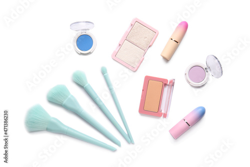 Set of decorative cosmetics with makeup brushes on white background