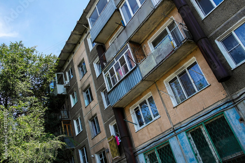 Soviet architecture. Ust-Kamenogorsk (kazakhstan) Apartment building. Soviet architectural style. Residential building. Soviet built multistory apartment building. Old residential area. Green trees photo