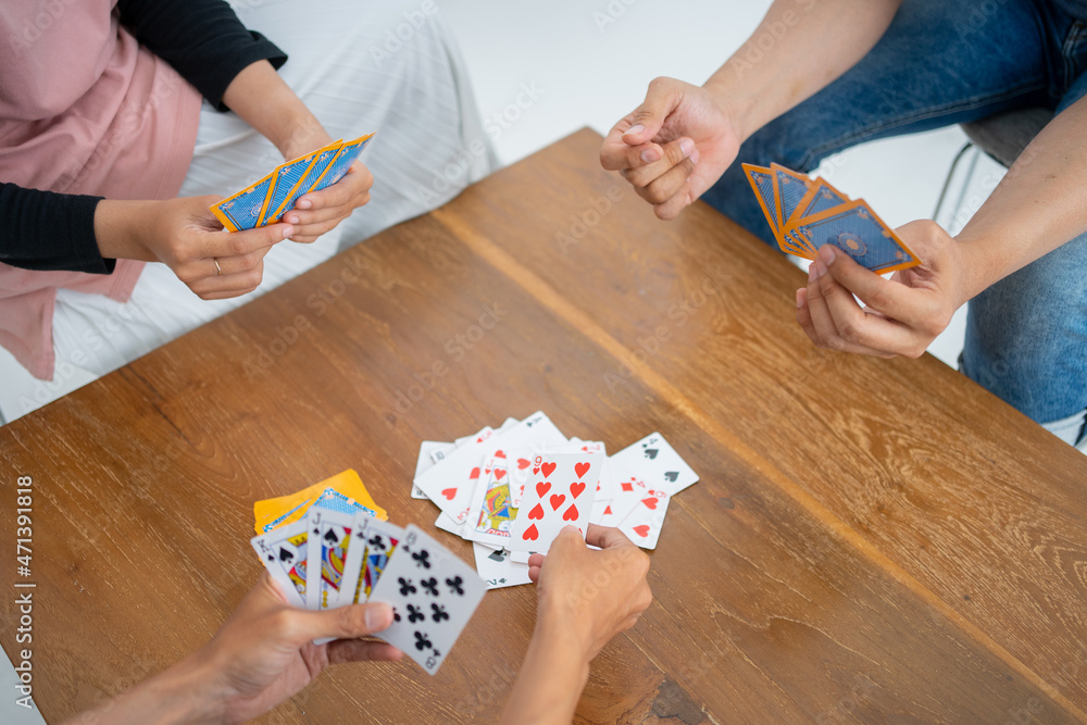 Obraz premium Hands issuing cards to table while playing cards together