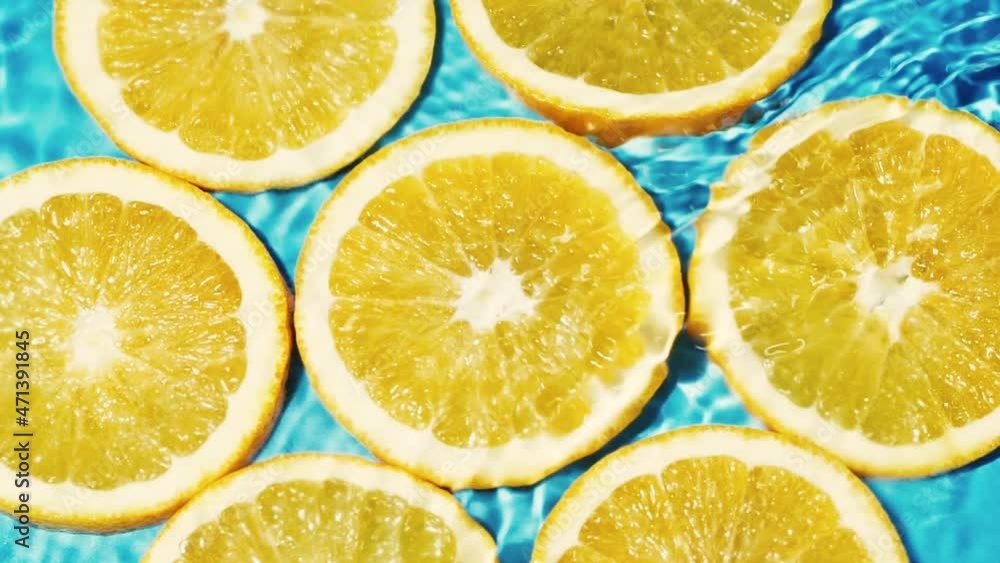 Macro orange fruit slices and blue water surface texture with ripple and splash Macro orange fruit slices and blue water surface texture with ripple and splash