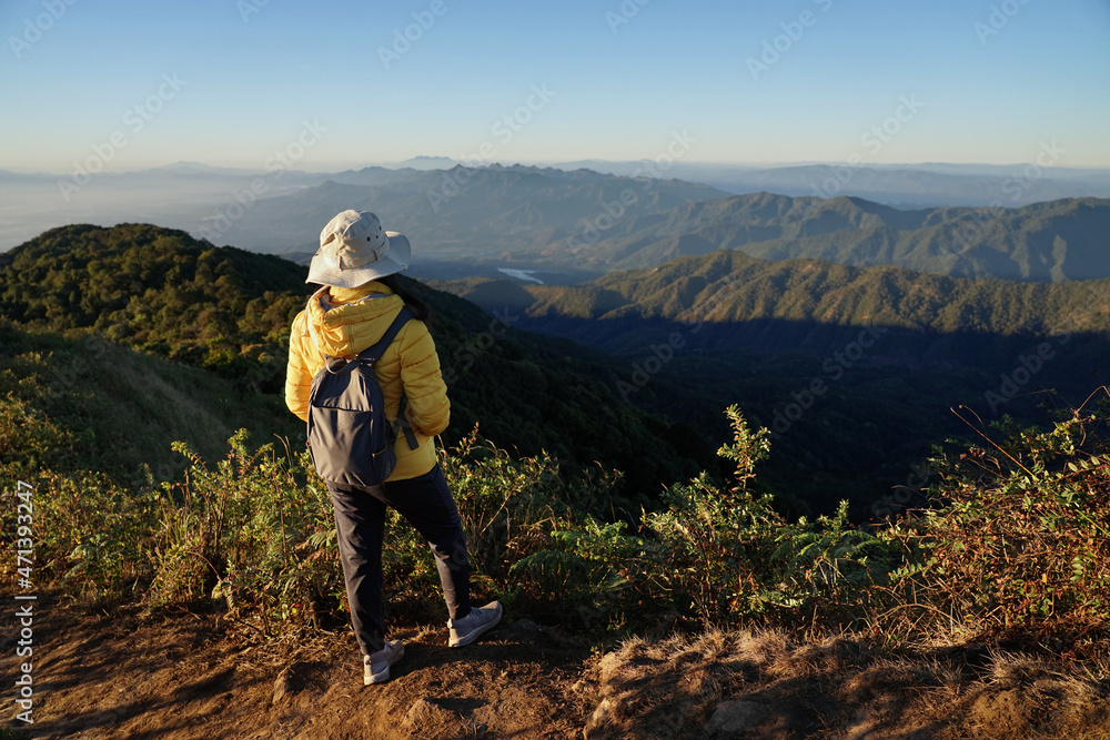 Happy young tourist on mountain enjoying valley view.