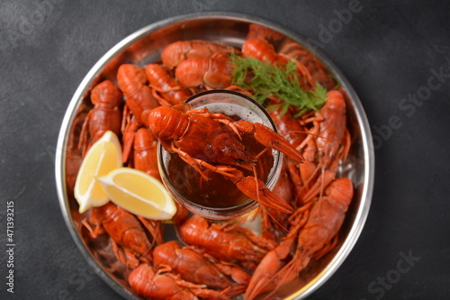 Red boiled crawfishes on table in rustic style. Asian Chinese Food Spicy Crayfish on an iron plate with a mug of beer.