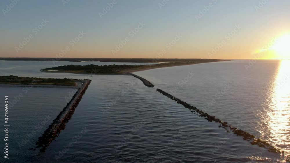 Aerial forward view of the sea and a motorboat passing through stone corridor. Sunrise. Soth Beach Cape Cod. USA Aerial forward view of the sea and a motorboat passing through stone corridor. Sunrise. Soth Beach Cape Cod. USA