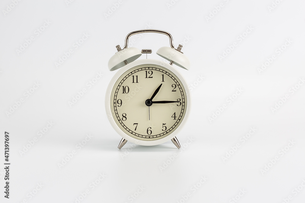 White retro clock alarm clock on white background shows 01:15 am or 01:15 pm or 13:15 White retro clock alarm clock on white background shows 01:15 am or 01:15 pm or 13:15