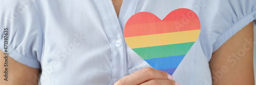 Woman holding multi colored lgbt heart closeup photo