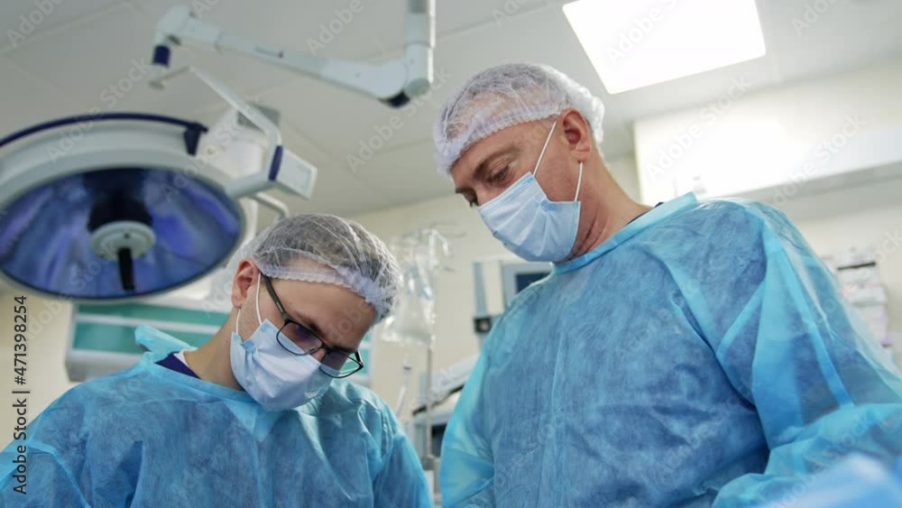 Medical operation some tools. Specialist putting device into a patient in the operating room. Skillful surgery concept Medical operation some tools. Specialist putting device into a patient in the operating room. Skillful surgery concept