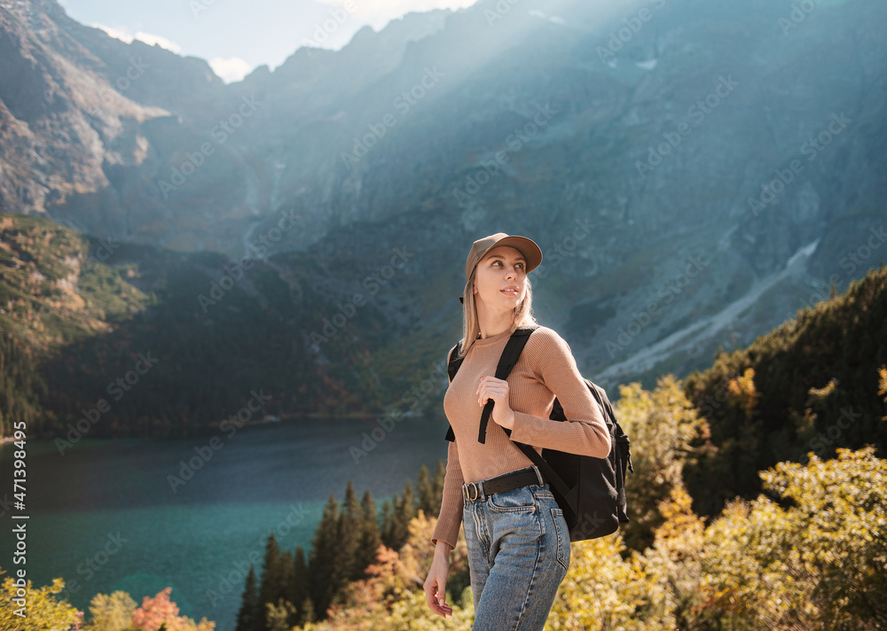 Naklejka premium Wanderlust and travel concept. Stylish traveler girl in hat looking at map, exploring woods.