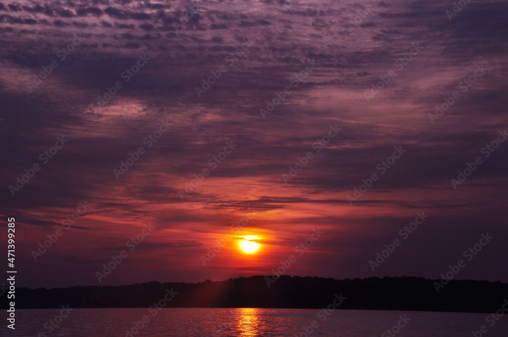 Early morning Purple orange sunrise over Mountain lake Reflecting off of water