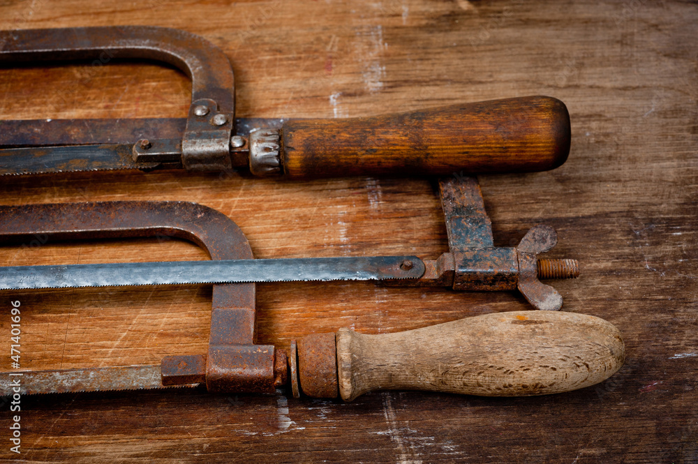 Old vintage metal hacksaws for metal shot on a wooden background.