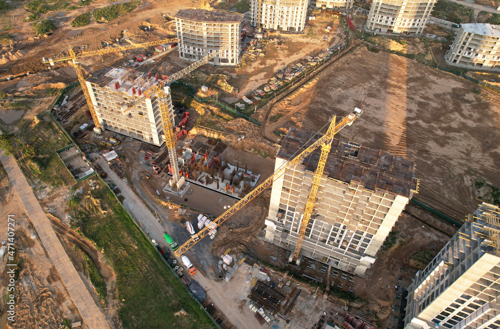 Construction site with tower crane on formworks. Crane on construction the building and multi-storey residential homes. Housing renovation concept, aerial view. Built environment.