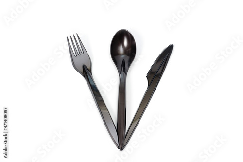 A set of plastic cutlery knife  fork and spoon in black  filmed on a white background