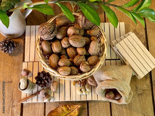 On the oak table there are wooden pallets with walnuts, hazelnuts and a vase with zamiakulkas on them