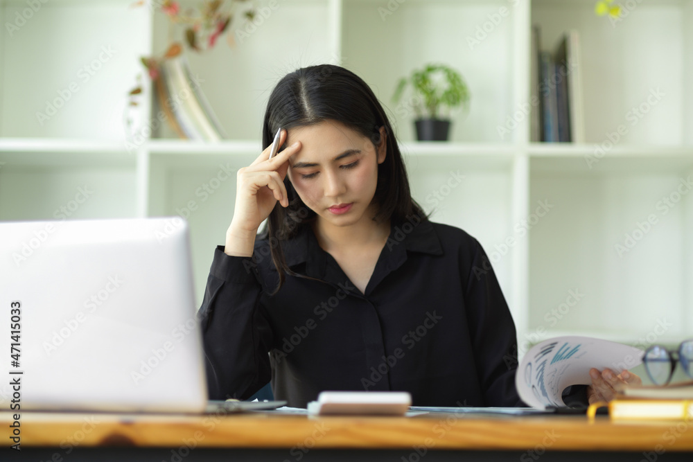 Stressed businesswoman working with laptop computer Stressed businesswoman working with laptop computer