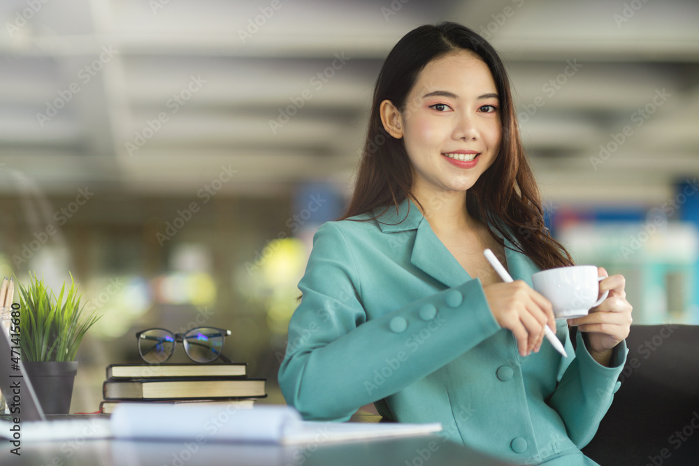 Elegant businesswoman sitting at her desk while drinking morning coffee. Elegant businesswoman sitting at her desk while drinking morning coffee.