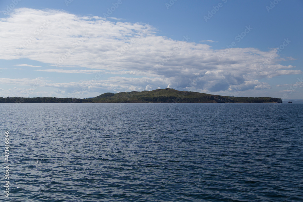 day view of the sea, islets, capes, white clouds and blue sky in the Novik harbor on island Russky in Vladivostok, Russia