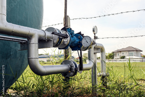 The valve system controls the water supply from a large water tank and water pressure gauge.