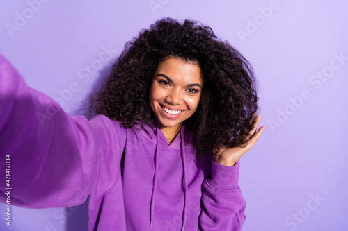 Photo of charming positive girl take selfie hand touch hair toothy smile isolated on purple color background