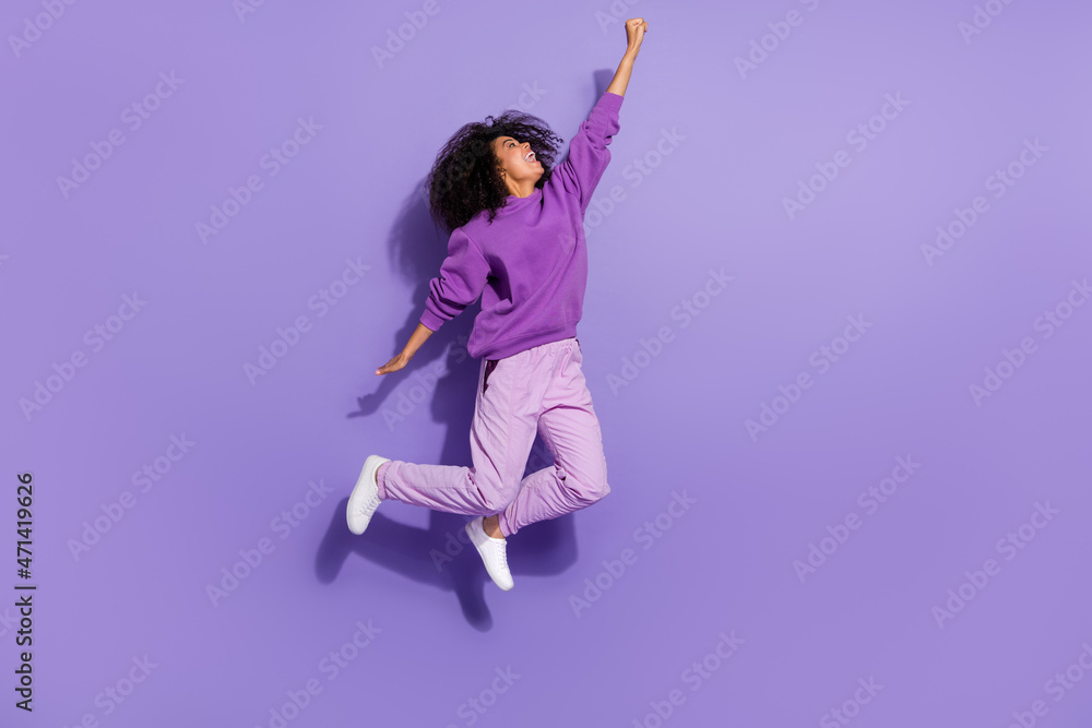 Full size photo of energetic attractive lady raise arm empty space fantasize isolated on purple color background
