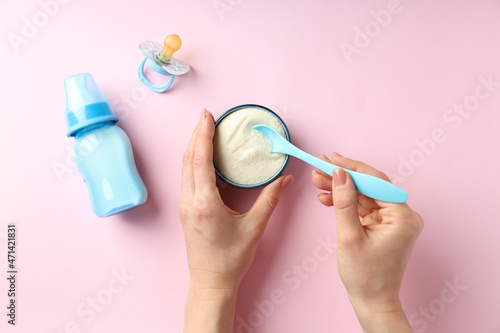 Concept of baby food with рowdered milk on pink background