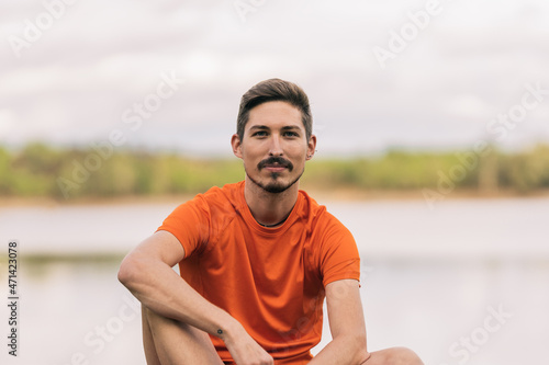 Portrait of a sportive man sitting on a park
