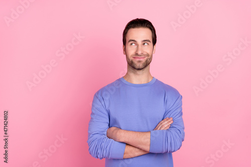 Photo of brunet nice guy crossed palms look empty space wear blue sweater isolated on pink color background