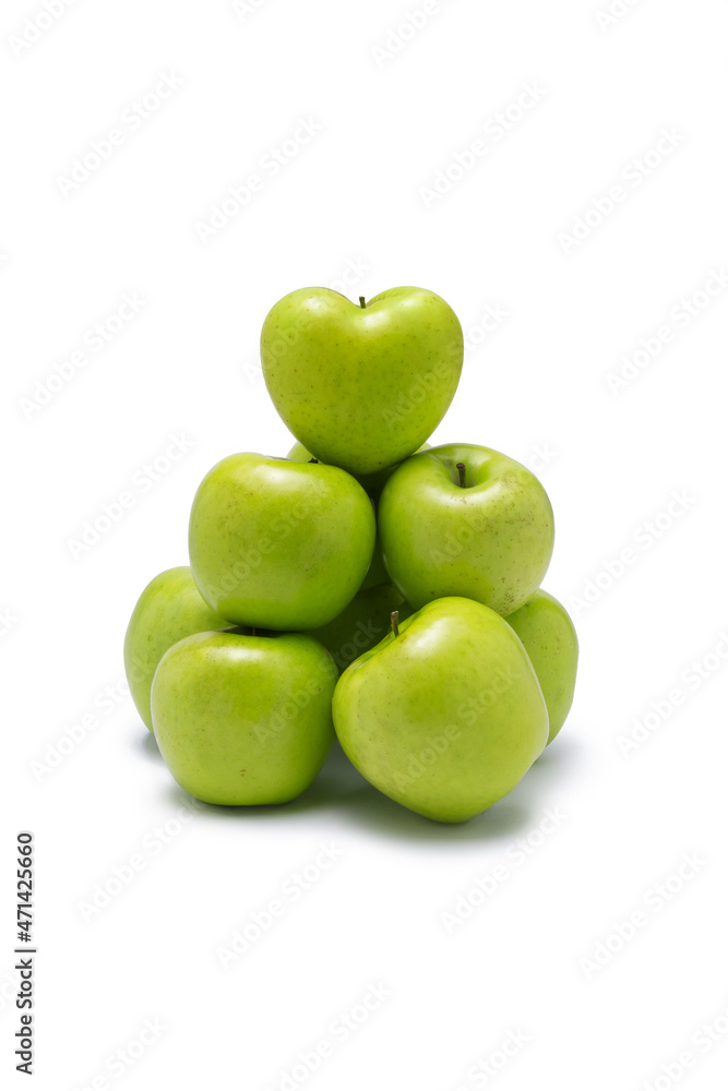 green apples in group stacked with one heart shaped on the top.
