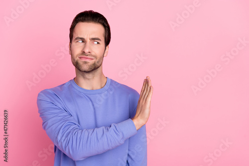 Photo of beard unsure guy dislike empty space wear blue sweater isolated on pastel pink color background photo