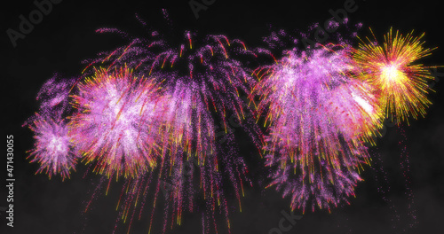 Image of yellow and pink fireworks exploding on black background
