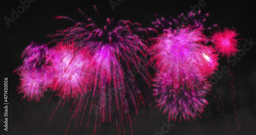 Image of pink fireworks exploding on black background