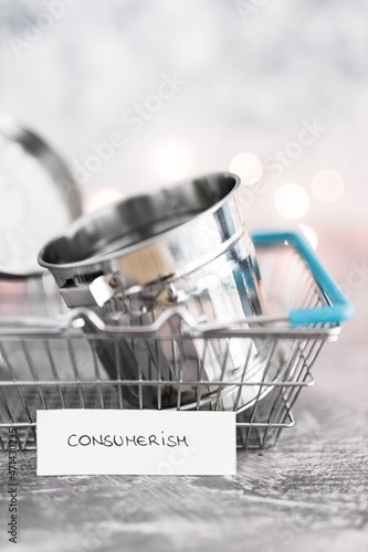 consumerism concept, shopping basket symbol of good to be purchased with recycling bin symbol of excess goods being produced or bought with labels