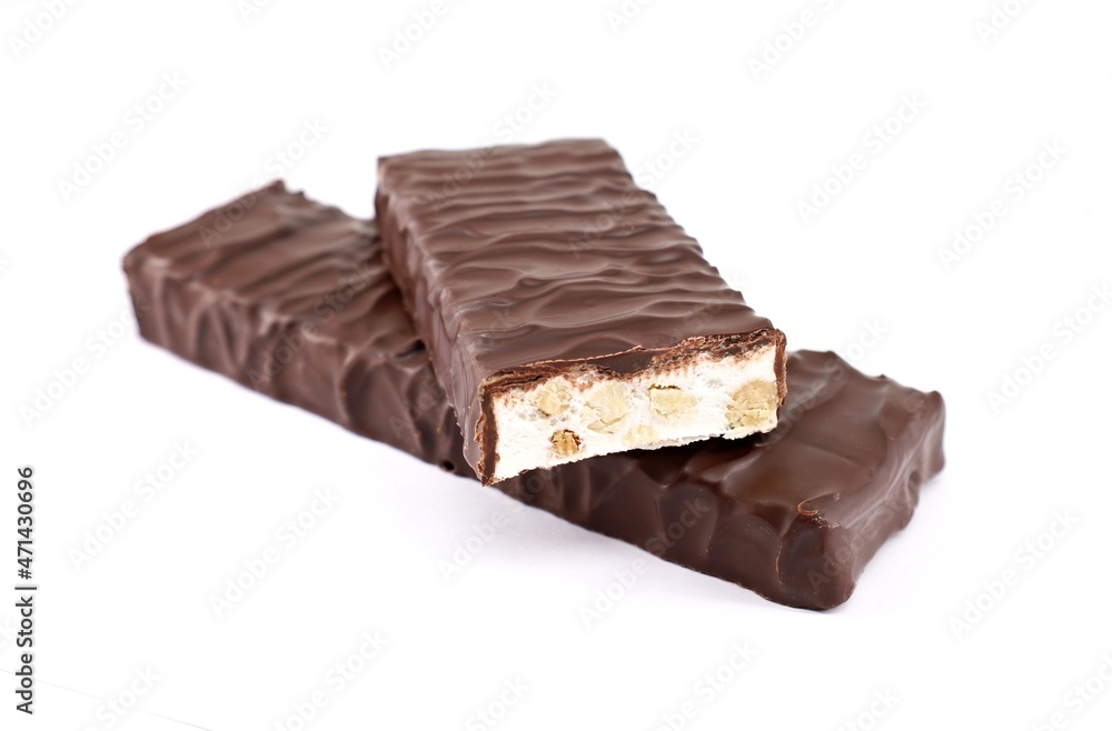 Two Torrone, one whole and the other cut, covered with dark chocolate on white background. It is a traditional nougat of Italy . Two Torrone, one whole and the other cut, covered with dark chocolate on white background. It is a traditional nougat of Italy .